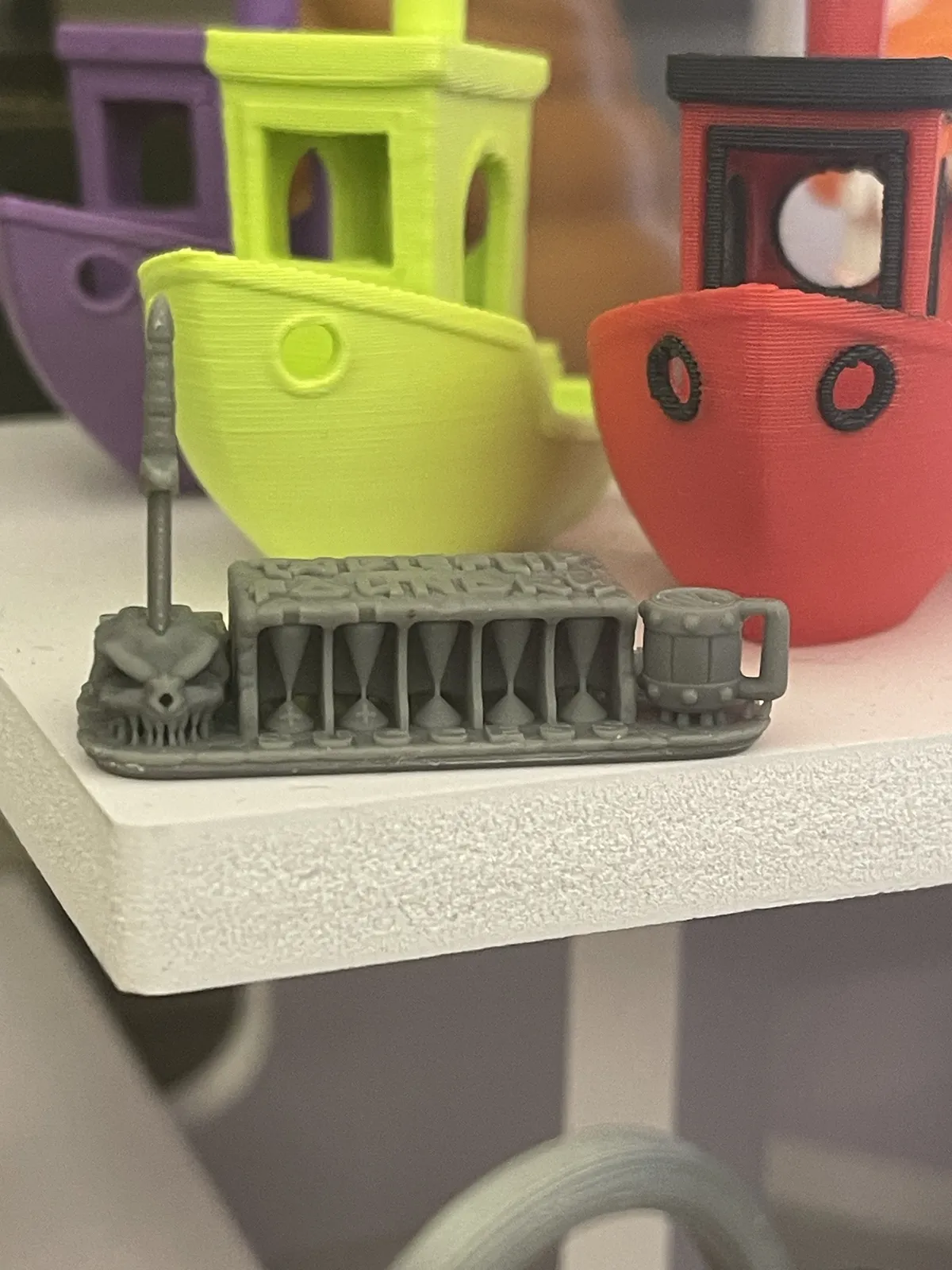 A front view of the same print, showing the five cones standing under the roof and the open mug handle.